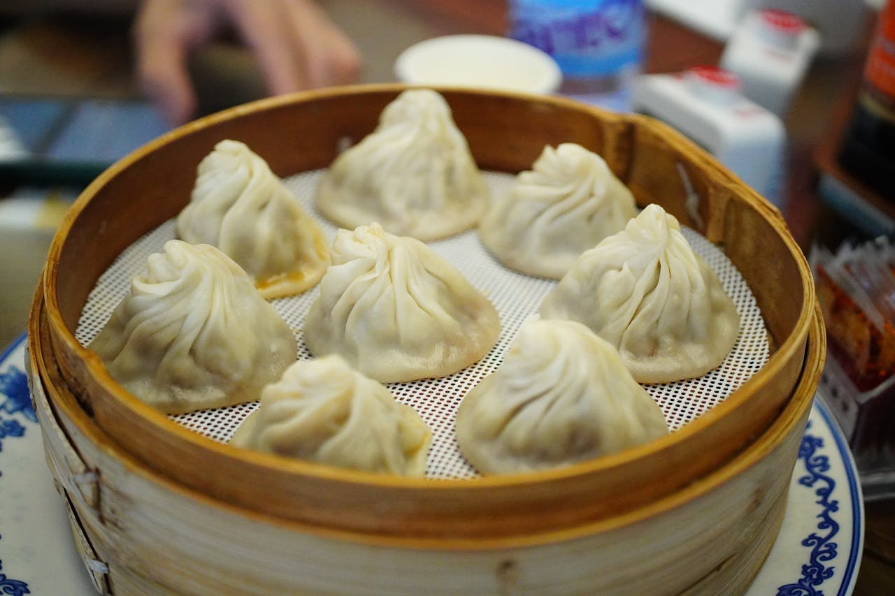 Delicious steamed dumplings served in a bamboo basket, perfect for a traditional Chinese meal.